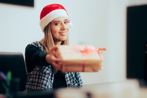 Smiling corporate worker handing a gift box on Christmas
