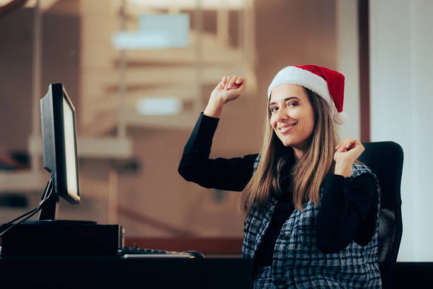 Happy Corporate Worker Celebrating at her Desk in the Office Cheerful workaholic employee receiving an xmas bonus secretary christmas gifts stock pictures, royalty-free photos & images