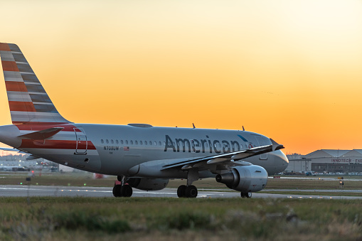 An airplane of American airlines taxiing on runway in Pearson International airport at dusk, Toronto,Canada.