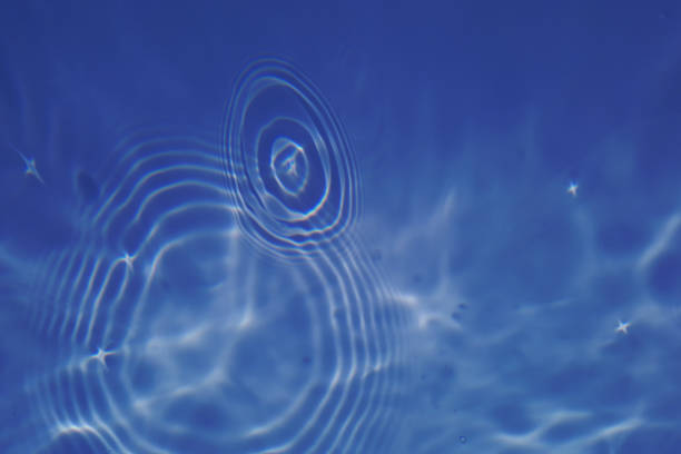 istock Defocus blurred transparent blue colored clear calm water surface texture with splashes and bubbles. Trendy abstract nature background. Water waves in sunlight with copy space. Blue watercolor shining 1437794936