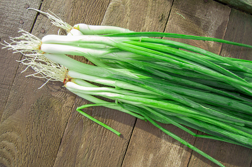 close-up of leek cut into slices with fresh stems on a wooden cutting board