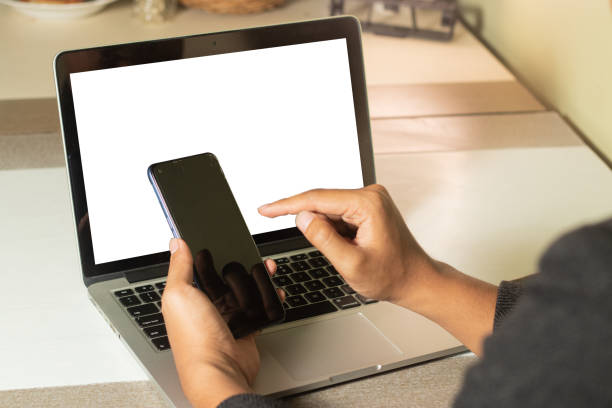 istock man using smart phone & laptop working at home 1437807388