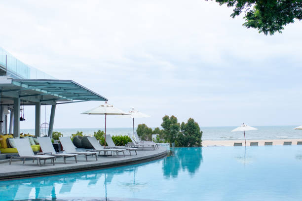 istock Gray pool lounge chairs by swimming pool. 1437810911