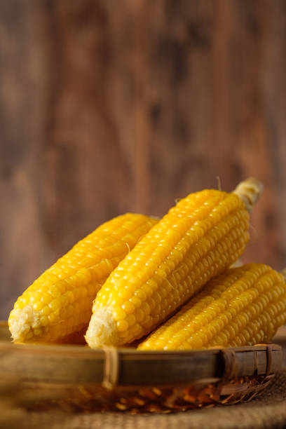 istock Group of corn cob in tray on wood table and wall 1437810967