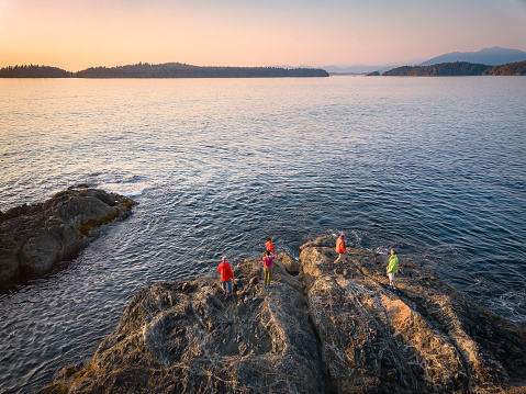 Drone photo of extended family of senior, mature and young adults hiking at sunset.  Bamfield, British Columbia, Canada.