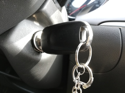 Close up composition, Modern car key and key chain in the keyhole inside car.