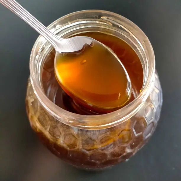 jar of homemade briar honey with a spoon showing the honey.