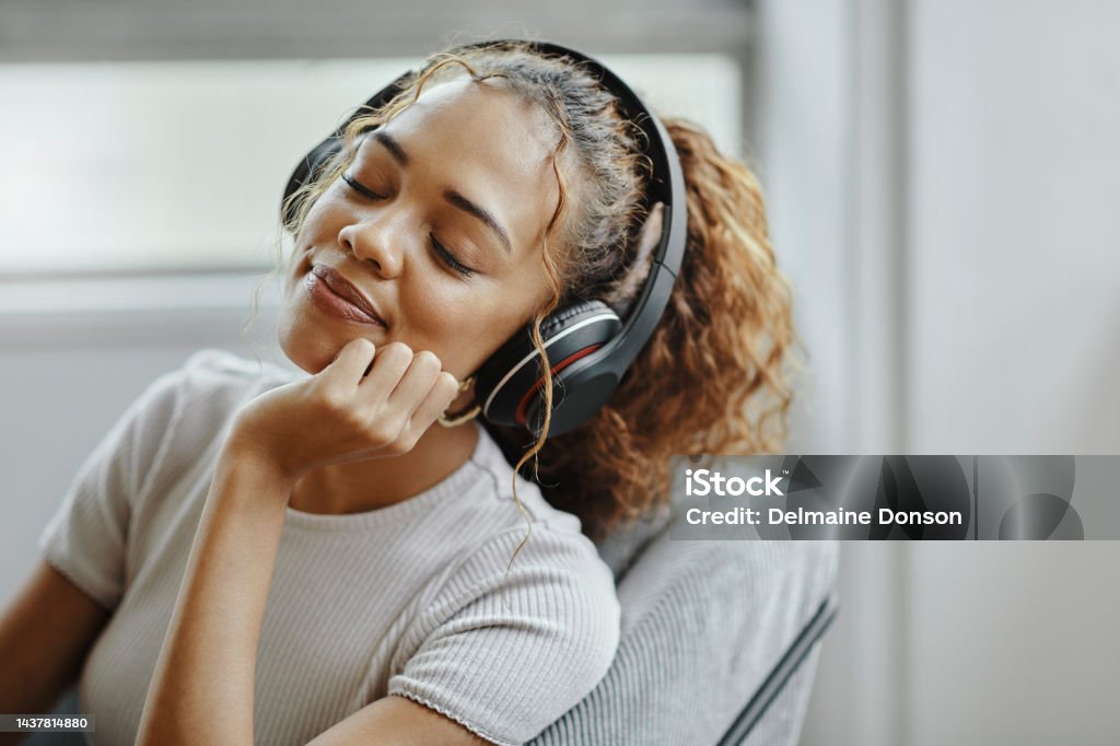 Music, relax and woman on a chair for peace, calm and happiness in the living room of her house. Face of a young girl sleeping with audio, radio or podcast in her headphones in the lounge of her home Music, relax and woman on a chair for peace, calm and happiness in the living room of her house. Face of a young girl sleeping with audio, radio or podcast on her headphones in the lounge of her home Music Streaming Service Stock Photo