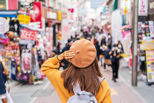 Young woman traveler walking on the Takeshita street in Harajuku the center of teenage fashion and cosplay culture in Tokyo