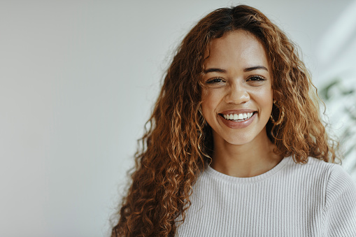 Face, portrait and happy with a black woman feeling positive, carefree or cheerful inside with a smile. Hair, teeth and beauty with an attractive young female posing next to mockup for advertising