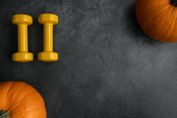 istock Dumbbells and autumn pumpkins, flat lay fall composition with copy space. 1437820871