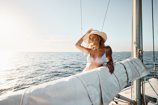 Young happy woman enjoying while traveling on a boat in summer day. Copy space.
