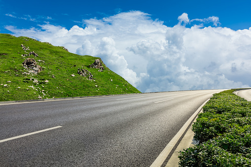 Empty asphalt road and mountain nature scenery under blue sky. Road and mountain background.