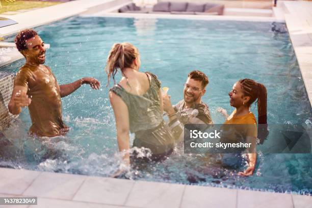 Cheerful couples having fun in summer day at the pool.