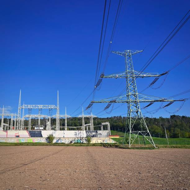 istock High voltage pylons - Blue sky with clouds and sun in nature. Concept for technology and industry. Further rising electricity and energy prices - the energy crisis caused by the war between Russia and Ukraine. 1437824326