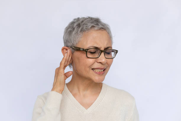 Portrait of irritated senior woman suffering from eardrum stock photo