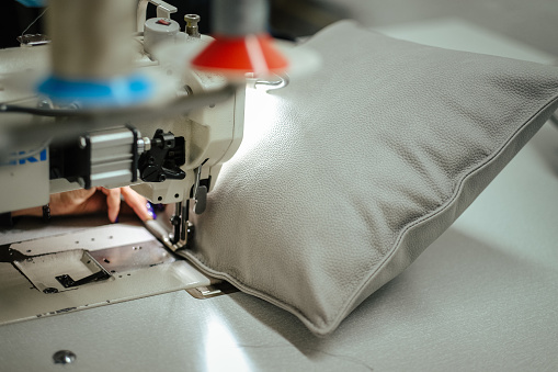 A closeup shot of a sewing machine making a pillow