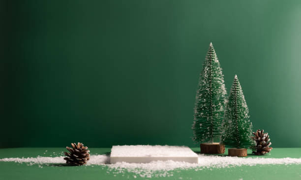 Photo of Minimalistic festive empty scene showcase for product, green background, tree Christmas toys, snow