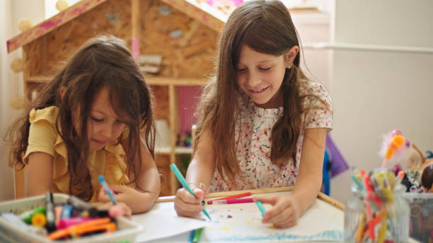 istock Sisters at home drawing and painting together 1437826096