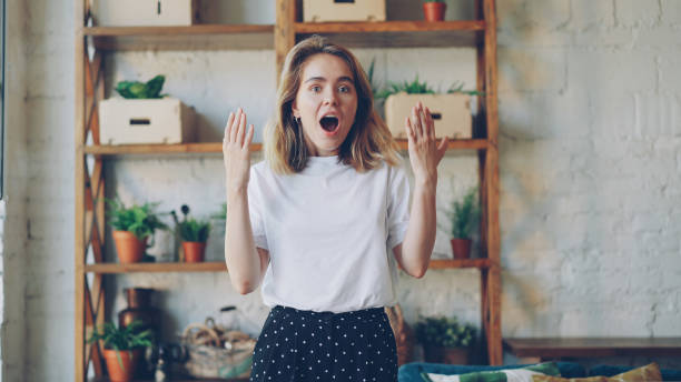 Portrait of shocked girl looking at camera with expression of excitement and surprise on her face. Positive emotions, good news and modern apartment concept. Portrait of shocked girl looking at camera with expression of excitement and surprise on her beautiful face. Positive emotions, good news and modern apartment concept. looking around stock pictures, royalty-free photos & images