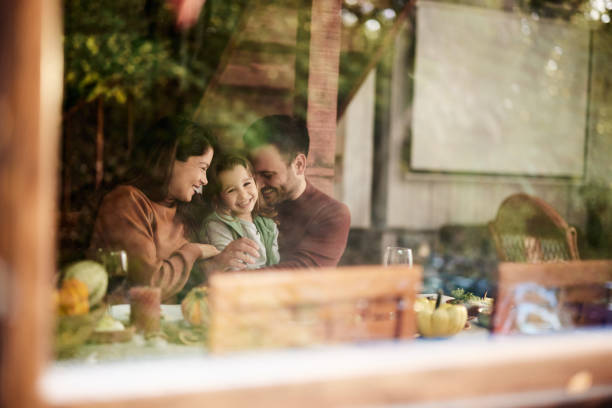 Happy parents enjoying with their daughter at dining table.