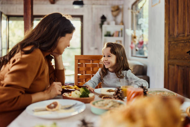 istock Happy mother and daughter talking during a meal at dining table. 1437832004