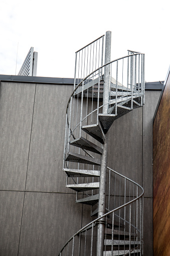 Emergency exit metal spiral staircase. Facade of the building.