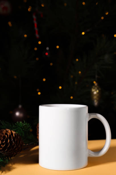 istock White ceramic mug close-up on a festive New Year's background with defocus lights. Text cup mockup, front view. 1437832507