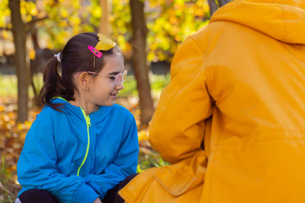 istock Mother and daughter playing with falling yellow leaves 1437832519