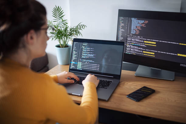istock Young woman coding on a laptop at home office. 1437832796