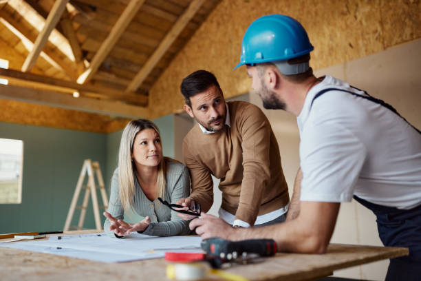 istock Young couple talking about housing design with manual worker. 1437833512