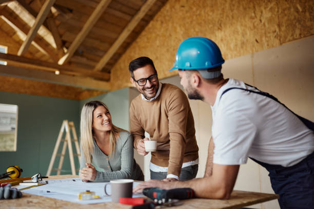 couple heureux discutant avec un ouvrier sur le chantier. - entrepreneur en bâtiment photos et images de collection