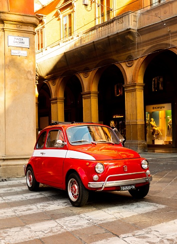 Bologna, Italy – July 04, 2021: Classic Italian car parked on roadside in Italian City of Bologna. Fiat 500. Red with white trim.
