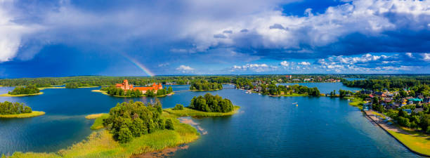 Aerial shot of an amazing lake surrounded by green forests and an island with an old castle An aerial shot of an amazing lake surrounded by green forests and an island with an old castle lithuania stock pictures, royalty-free photos & images