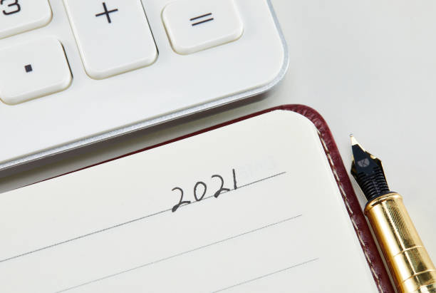 istock New Year 2021 Notebook with a ballpoint pen and a calculator on a white background 1437838378