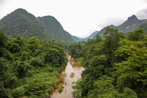 A river flowing through forested hills in the Phong Nha Ke Bang National Park in Vietnam.