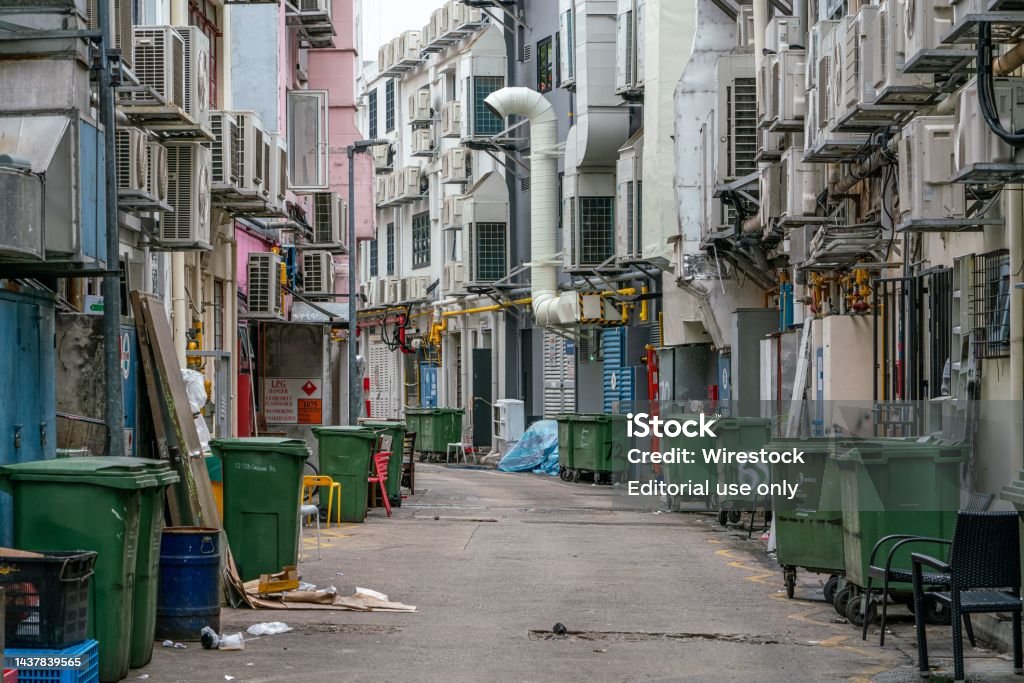 Back alley view at Boat Quay, Singapore. – August 03, 2022: The facade with rows of air conditioners and trash containers is hidden in the back alley at Boat Quay, Singapore. Air Conditioner Stock Photo