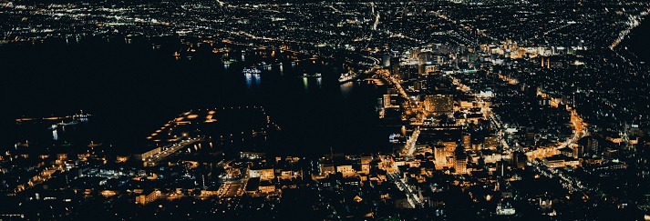 A night city view with illuminated streets and buildings, drone view, airplane window view