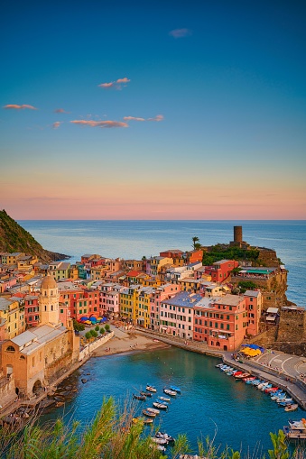 A vertical drone shot of a small shoreside village with colorful buildings in Cinque Terre