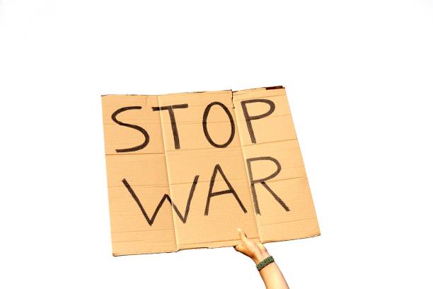 istock A Cardboard Signs saying Stop War held by hands on a white background 1437840441