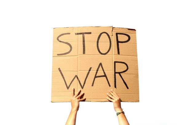 istock A Cardboard Signs saying Stop War held by two hands on a white background ready for montage 1437840443