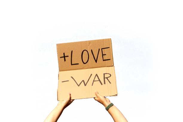 istock A Cardboard Signs saying More Love, Less War held by two hand on a white background 1437840476