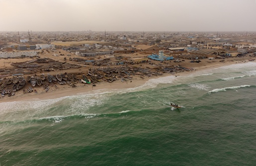 Aerial landscape of fishing port of Nouakchott, Mauritania. The photo shows the port and a fishing boat leaving it.