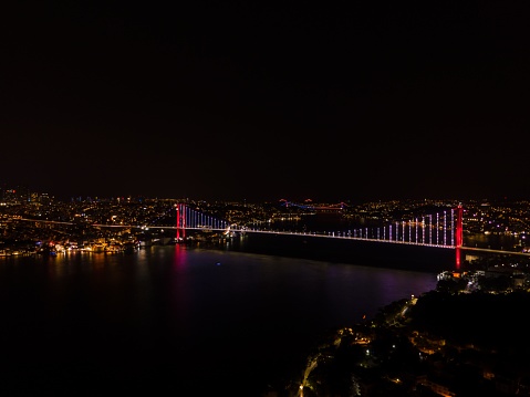 The aerial view of the glowing bridges above Bosphorus Strait at night. Istanbul, Turkey.