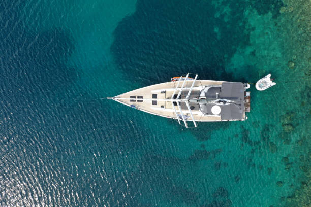 vue aérienne d’un voilier dans une mer d’un bleu cristallin par une chaude journée ensoleillée en été - crystally photos et images de collection