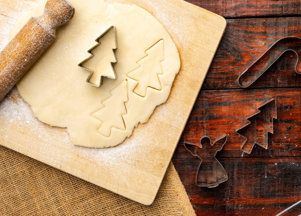 istock Overhead shot of raw dough and Christmas cookie cutters on rustic kitchen table 1437842113