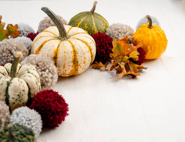 Pumpkins and yarn pompoms with space for your text - autumn themed background