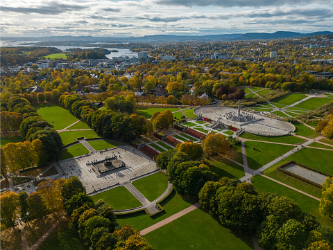 Aerial view of statues in the public Vigeland Park in Oslo, Norway. The colorful trees signal the leaves are changing color. Taken October 9, 2022.