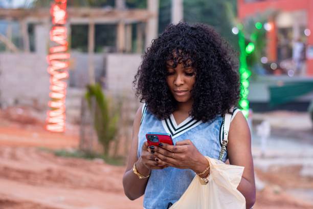 istock black woman using her phone outdoors 1437842449