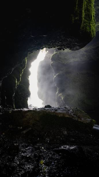 istock Vertical shot of rocks and moss inside a dark cave 1437846041